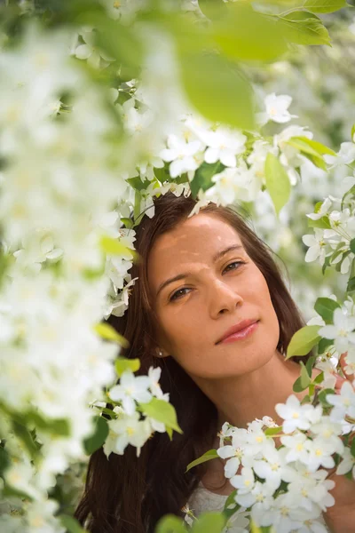 Porträt des Frühlings brünettes Mädchen steht im Freien in blühenden tr — Stockfoto