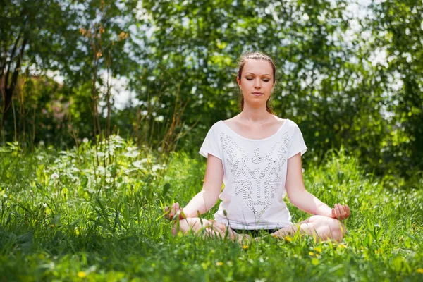 Young woman in sportswear working out outdoors in a park on sunn — Stockfoto