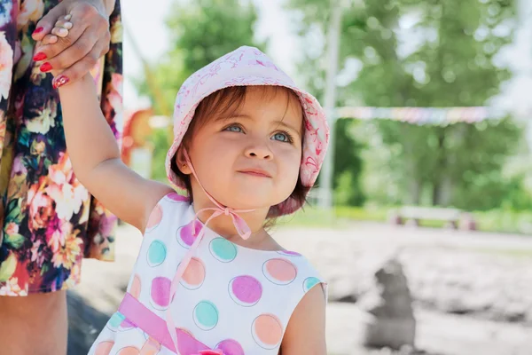 Portrait of little girl holding mom's hand, walking in a park on — Stock Photo, Image