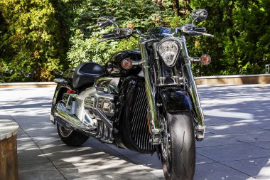 Güzel, siyah motosiklet gücü ve güzelliğiyle onu etkiliyor. Krom parıltılı detaylar siyah bir motosiklette harika görünüyor.