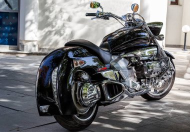 Güzel, siyah motosiklet gücü ve güzelliğiyle onu etkiliyor. Krom parıltılı detaylar siyah bir motosiklette harika görünüyor.