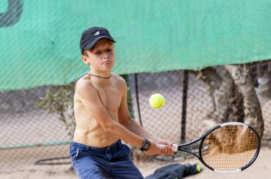 Genç tenisçi ilk yarışmalarına katılır. En zor atışları bile başarıyla yapıyor..