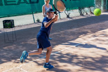 Genç tenisçi ilk yarışmalarına katılır. En zor atışları bile başarıyla yapıyor..