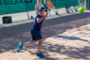 Genç tenisçi ilk yarışmalarına katılır. En zor atışları bile başarıyla yapıyor..