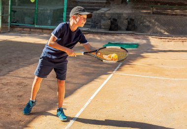 Genç tenisçi ilk yarışmalarına katılır. En zor atışları bile başarıyla yapıyor..