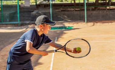 Genç tenisçi ilk yarışmalarına katılır. En zor atışları bile başarıyla yapıyor..