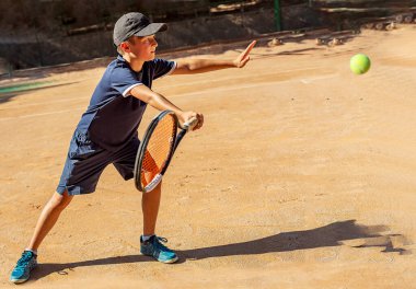 Genç tenisçi ilk yarışmalarına katılır. En zor atışları bile başarıyla yapıyor..