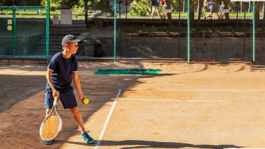 Genç tenisçi ilk yarışmalarına katılır. En zor atışları bile başarıyla yapıyor..