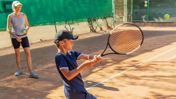 若いテニス選手は彼の最初の競技会に参加する 彼は成功裏に最も困難なボールを扱う — ストック写真