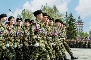 Omsk garnizonunun askerleri ve adayları Zafer Günü geçit töreninin konvoyu içinde açık sıra bekliyor..