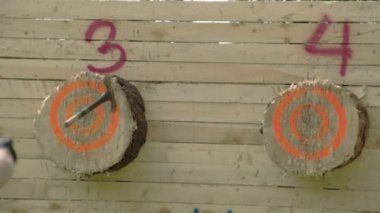 bir adam, dördüncü tahta balta atıyor