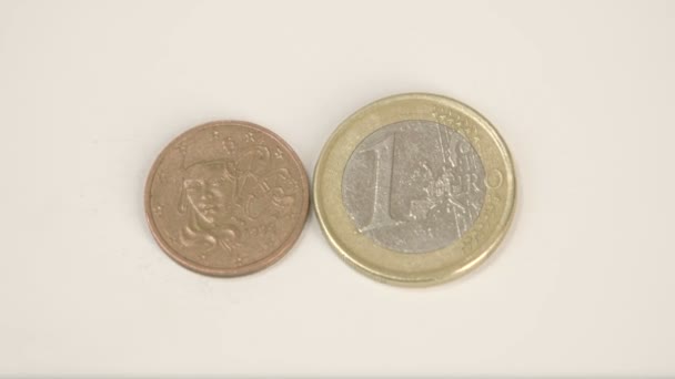 Una pequeña moneda de bronce de Francia y una moneda de 1 euro — Vídeos de Stock