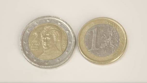 Une pièce de 2 euros autrichienne et une pièce de 1 euro autrichienne sur la table — Video