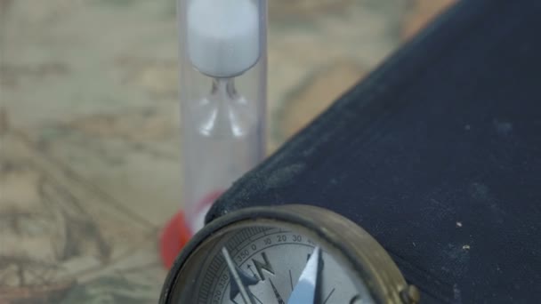 Eine Kompass-Sanduhr und eine Bibel auf einer Karte — Stockvideo