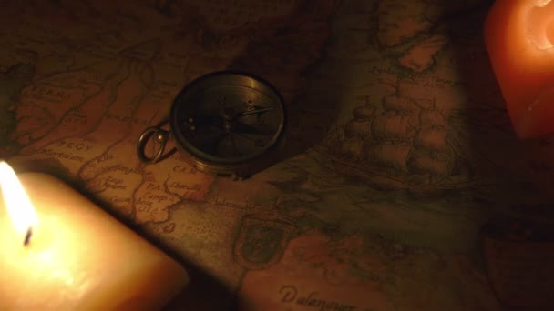 Two candles lit near the map and the compass — Stock Video