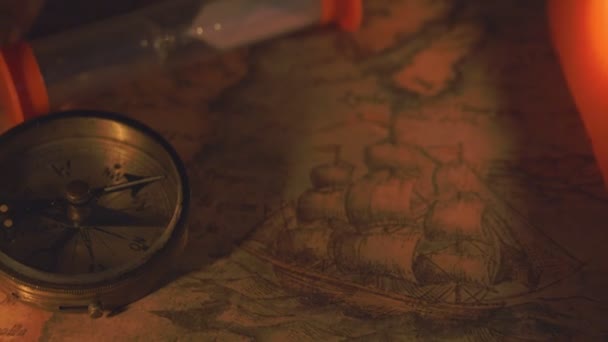 La boussole et le sablier près des bougies 