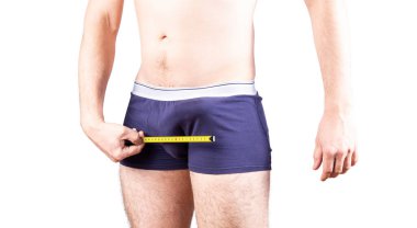 Penis size measure concept. Man measures his penis in underwear. Erectile and potency concept.