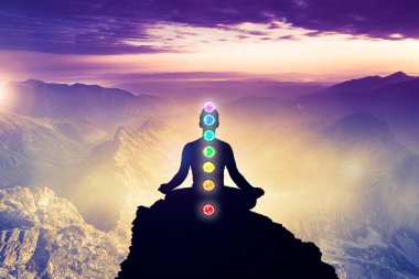 Yoga Lotus pozisyonunda yedi çakrayla meditasyon yapan adamlar. Farkındalık ve özgüven pratiği. Dağlardaki meditasyonun silüeti arka plan manzarası