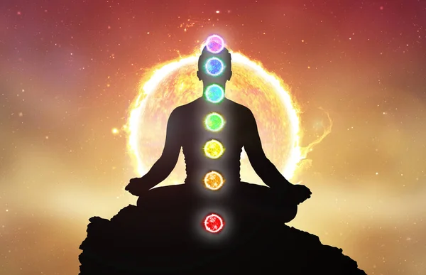 Chakras and meditating men in yoga lotus position. Mindfulness and self awereness practice. Silhiuette of meditation with chakras on sun background.