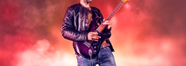 Rock gitaristi elektro gitarda solo çalar. Sanatçı ve müzisyen rock yıldızı gibi şarkı söylüyor. Gitarist sahnede çalıyor.. 