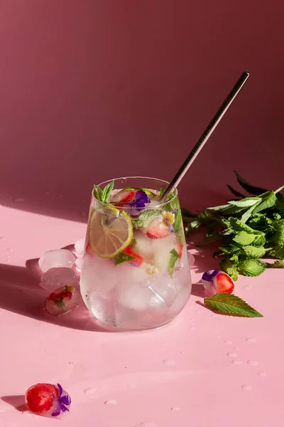 Non-alcoholic cocktail with frozen strawberries, mint and flowers.