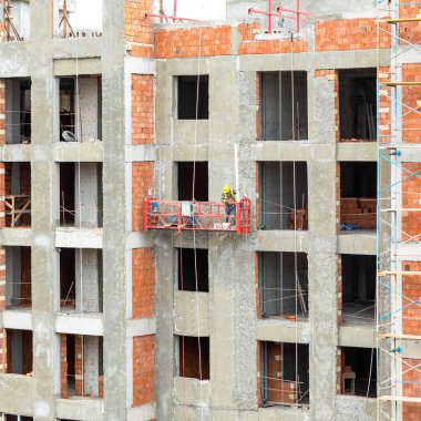 İnşaat alanında darağacına sahip yüksek binalar, bir duvar boyuyor.