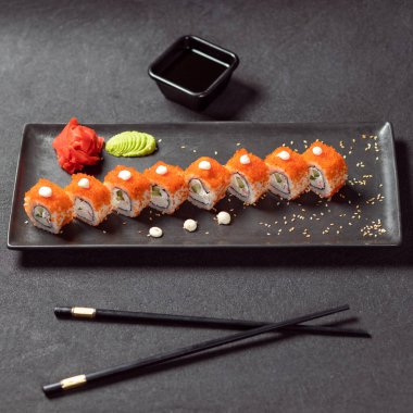 Soya, wasabi, zencefil ve siyah çubuklu California Unagi Suşi Roll.
