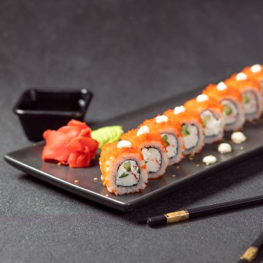 Soya, wasabi, zencefil ve siyah çubuklu California Unagi Suşi Roll.