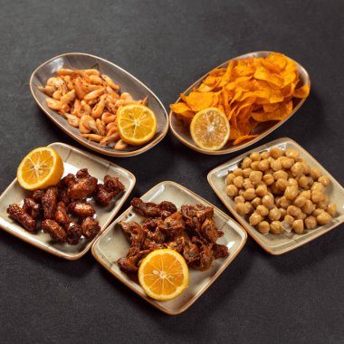 Bira aperatifleri, ızgara balık, bezelye, peynir, cips, tavuk