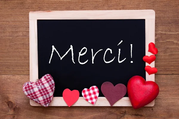 Blackboard med textil hjärtan, text Merci betyder Tack — Stockfoto