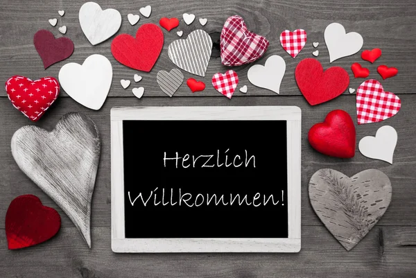 Chalkbord s mnoha červenými srdci, Willkommen znamená vítaný — Stock fotografie