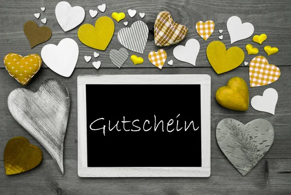 Chalkbord med många gula hjärtan, gutschein betyder kupong — Stockfoto