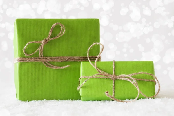 Два зеленых подарка на снегу, эффект Боке — стоковое фото