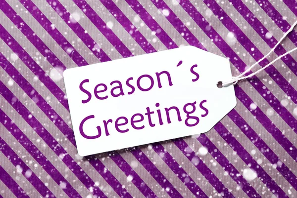 Etikett auf lila Geschenkpapier, Schneeflocken, Textgrüße der Jahreszeiten — Stockfoto