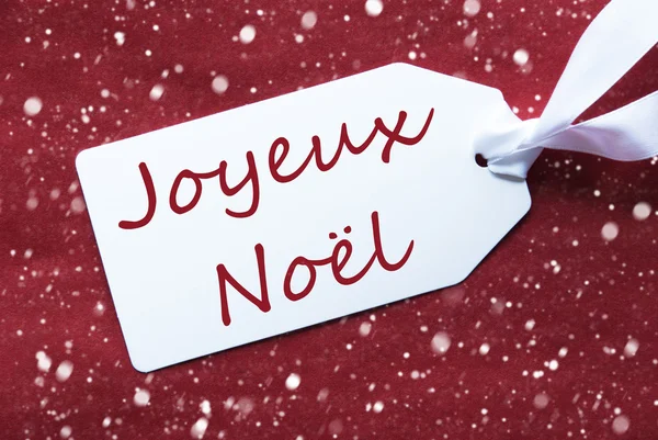 Label op rode achtergrond, sneeuwvlokken, Joyeux Noel betekent vrolijk kerstfeest — Stockfoto