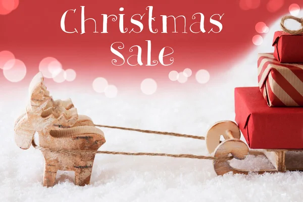 Reno con trineo, fondo rojo, venta de Navidad de texto — Foto de Stock