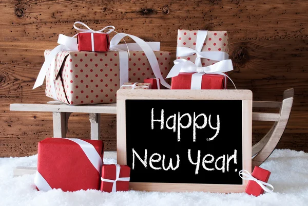 Sáně s dárky na sněhu, Text šťastný nový rok — Stock fotografie