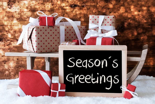 Slee met geschenken, sneeuw, Bokeh, tekst Seasons Greetings — Stockfoto