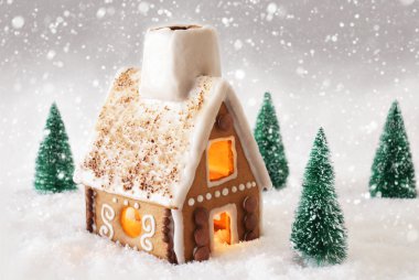 Kar kar taneleri ve gri arka plan üzerinde ev gingerbread