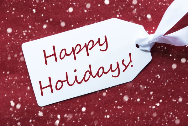 En etikett på röd bakgrund, snöflingor, Text Happy Holidays — Stockfoto