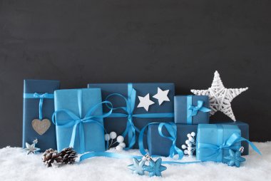 Mavi hediyeler Noel dekorasyon, siyah çimento duvar, kar ile