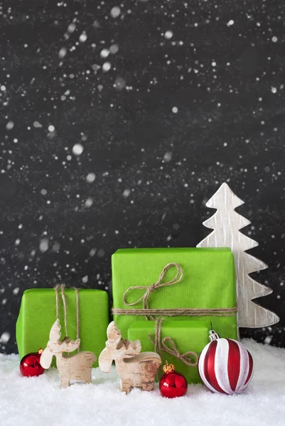 Vertikale rote und grüne Weihnachtsdekoration, schwarze Zementwand, Schneeflocken — Stockfoto