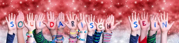 ( 영어 ) Children Hands Solidarisch Sein Means Solidarity, Red Christmas Background — 스톡 사진