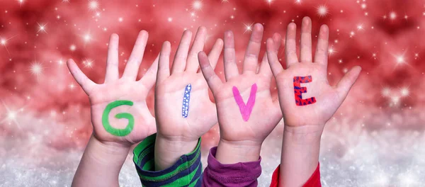 Children Hands épület Word Give, piros karácsonyi háttér — Stock Fotó