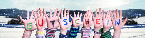 Dzieci Ręce Budowanie Word Gutschein oznacza kupon, śnieg tle zima — Zdjęcie stockowe