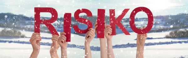 Persone mani che tengono parola Risiko significa rischio, sfondo invernale nevoso — Foto Stock