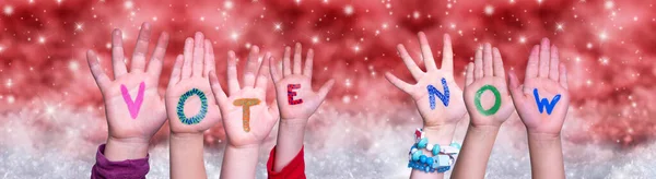 Kinderhände basteln Wortwahl jetzt, roter Weihnachtshintergrund — Stockfoto