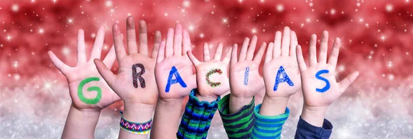 Barn händer Gracias innebär tack, röd jul bakgrund — Stockfoto