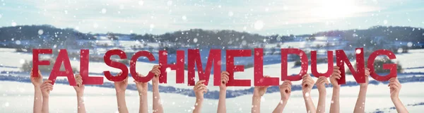 人们手握文字Falschmeldung意为假新闻，雪冬背景 — 图库照片