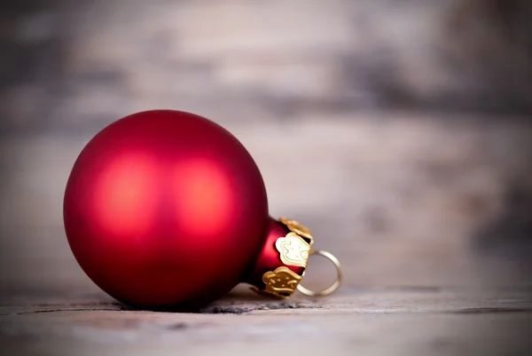 Eine rote Weihnachtskugel auf Holz — Stockfoto